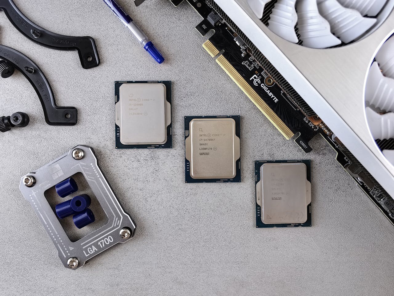 Home Overhead view of CPUs, graphics card, and mounting equipment on gray background, emphasizing modern technology.